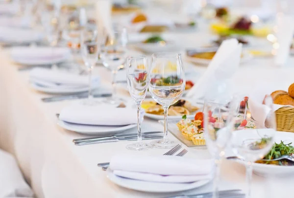 Mesa muy bien servida en un restaurante sobre un mantel blanco — Foto de Stock