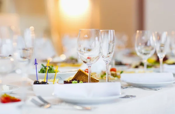 Mesa muy bien servida en un restaurante sobre un mantel blanco — Foto de Stock