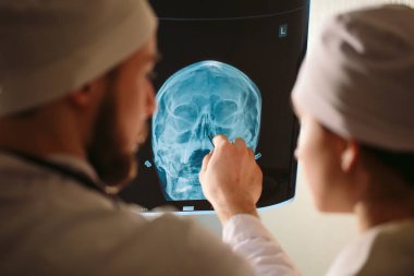 Doktorlar hastane odası yakınında hastanın röntgenini izliyor.