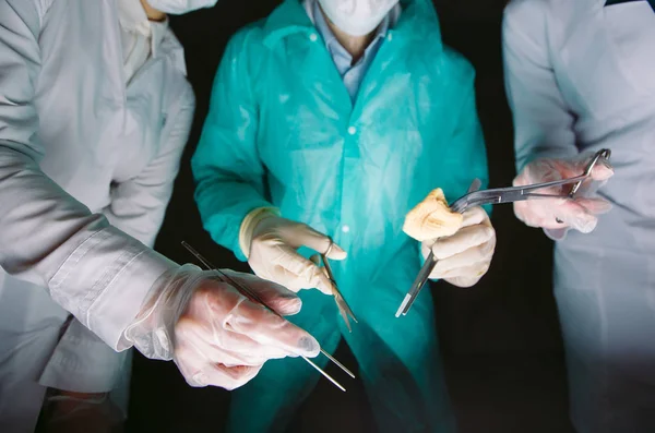 Manos cerca de cirujanos sosteniendo instrumentos médicos. El cirujano hace una operación — Foto de Stock