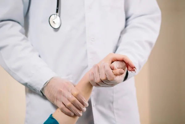 Arzt hält Mädchen an der Hand und misst den Puls des Patienten — Stockfoto