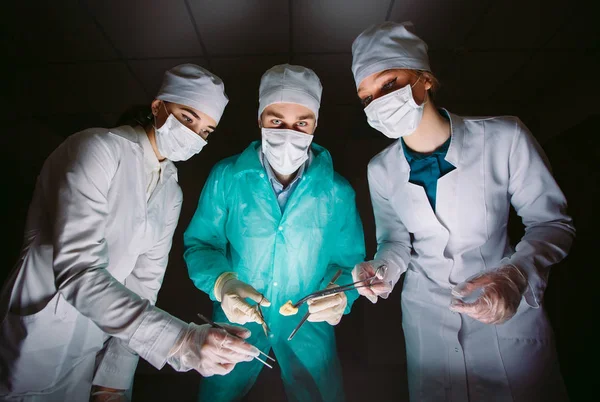 Chirurg provede operaci v temné místnosti. — Stock fotografie