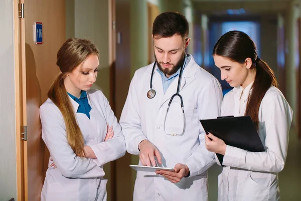 Médicos discutiendo pacientes cardiograma en el comprimido —  Fotos de Stock