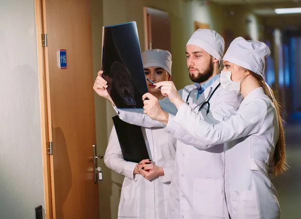 Médicos assistindo raio-X do paciente perto do quarto do hospital . — Fotografia de Stock