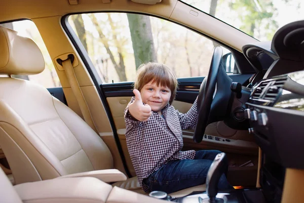 Niño en el coche negro con interior beige . — Foto de Stock