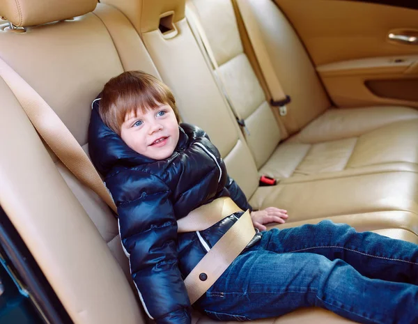 Baby boy in the black car with beige interior. — Stock Photo, Image