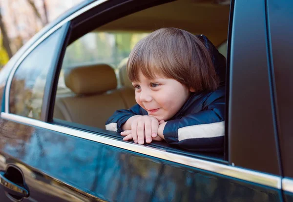 Niño en el coche negro con interior beige . — Foto de Stock