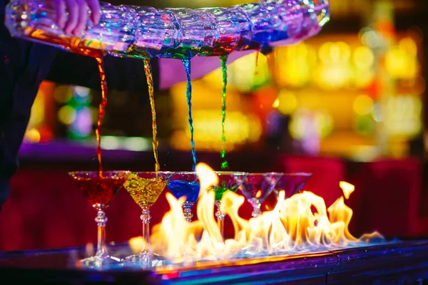 Barmann-Show. Barkeeper schenkt alkoholische bunte Cocktails ein. — Stockfoto