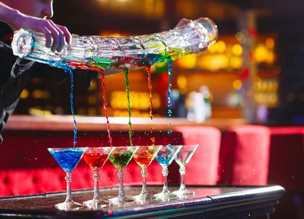 Barmen gösterisi. Barmen alkollü renkli kokteyller döker. — Stok fotoğraf