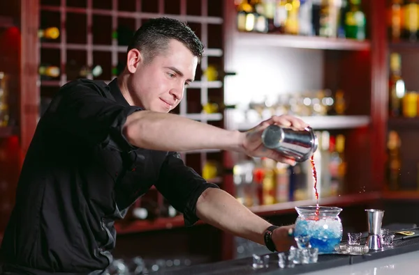 Barman derramando coquetel fresco em vidro extravagante . — Fotografia de Stock