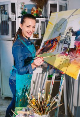 Resim Stüdyosunda Güzel Kız bir resim çizer.