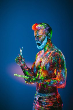 Kavram. Berber dükkanında sakallı bir adam. Berber dükkanında şık bir sakallı adam kesilmiş. Adam ultraviyole tozu ile dekore edilmiştir.