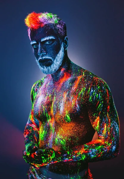 Concept. A bearded man in Barbershop. A stylish bearded man is trimmed in Barber Shop. The man is decorated in ultraviolet powder.