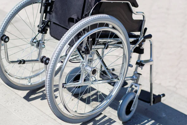 Parkta merdivenlerin yanında tekerlekli sandalye.