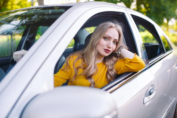 Una giovane bella ragazza sta guidando una macchina . — Foto Stock