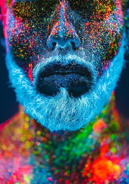 Conceito. Retrato de um homem barbudo. O homem é pintado em pó ultravioleta . — Fotografia de Stock