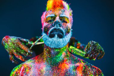 Kavram. Berber dükkanında sakallı bir adam. Berber dükkanında şık bir sakallı adam kesilmiş. Adam ultraviyole tozu ile dekore edilmiştir.