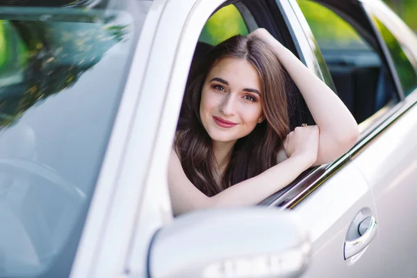 Una chica bonita joven está conduciendo un coche . — Foto de Stock