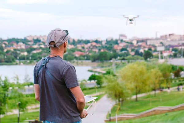 Genç adam uçan drone izlerken ve gezinme. — Stok fotoğraf