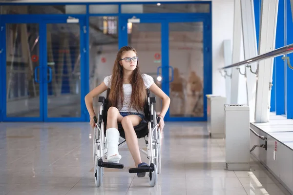 Молодая девушка в инвалидной коляске стоит в коридоре больницы — стоковое фото