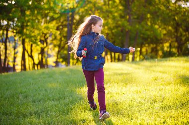 Kız koşmak ve sabun kabarcıkları ile oynamak.