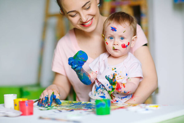 Mom and Daughter paint on canvas at the drawing school.