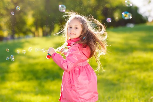 Les filles courent et jouent avec des bulles de savon . — Photo