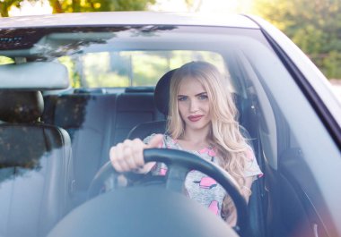 Genç güzel bir kız araba kullanıyor..