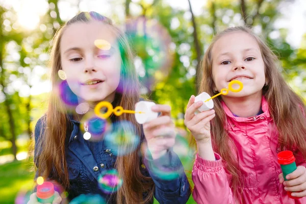 Дівчата грають з мильними бульбашками у весняний час . — стокове фото