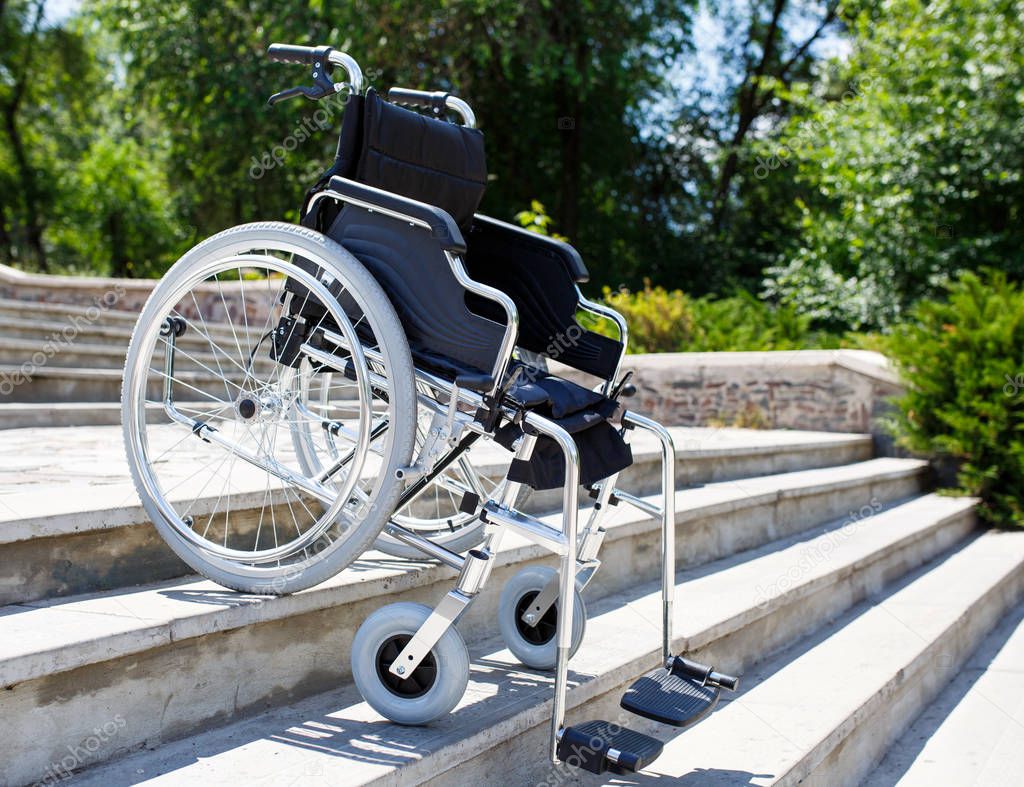 Wheelchair near the steps outdoors in the park.