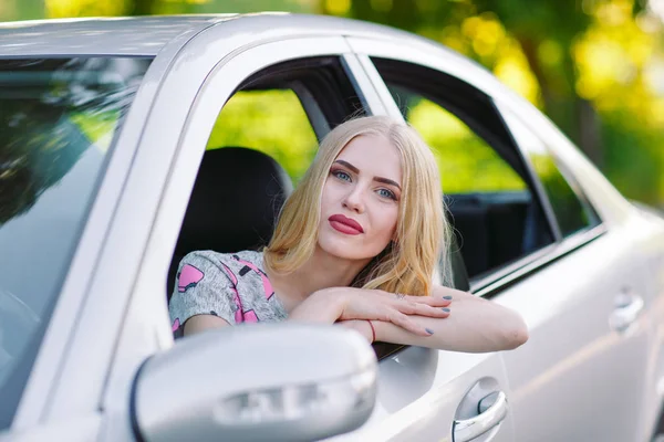 Una chica bonita joven está conduciendo un coche . — Foto de Stock