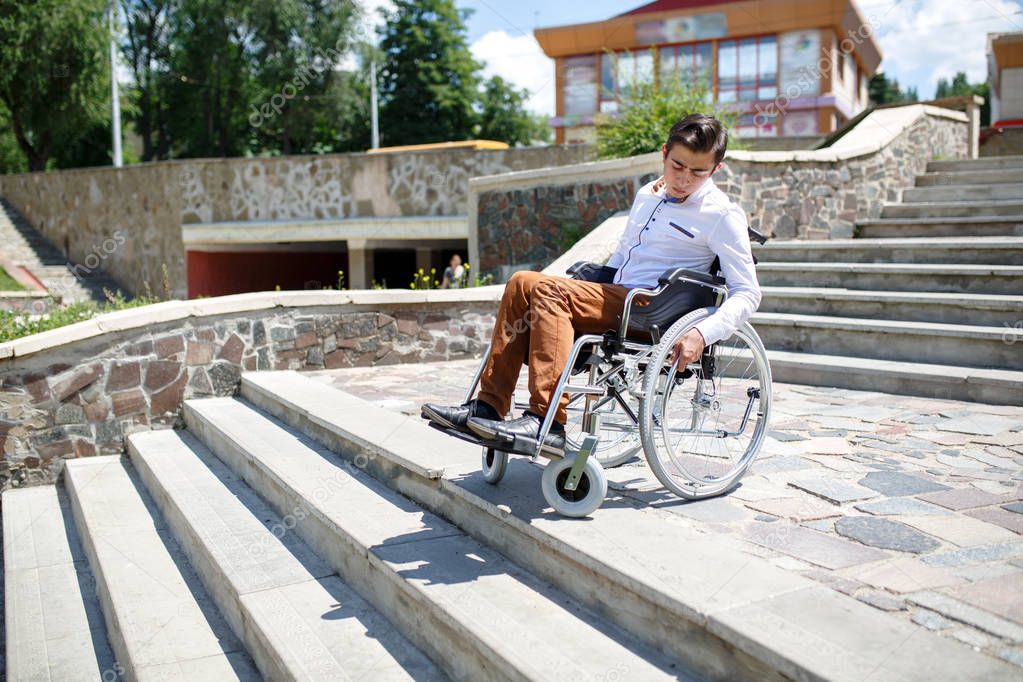A young man in a wheelchair who can not descend the stairs.