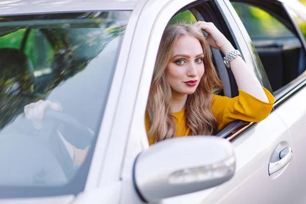 Una chica bonita joven está conduciendo un coche . — Foto de Stock