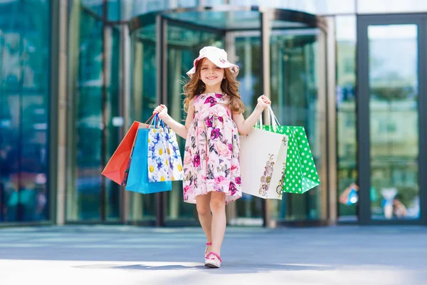 Το χαριτωμένο μικρό κορίτσι για ψώνια. Πορτρέτο του ένα παιδί με τσάντες αγορών. Για ψώνια. Κορίτσι — Φωτογραφία Αρχείου