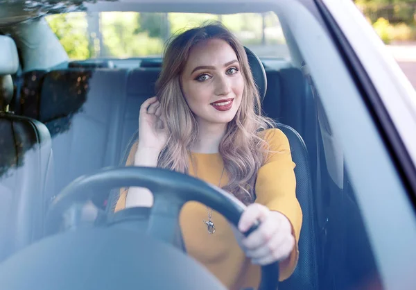 Una chica bonita joven está conduciendo un coche . — Foto de Stock