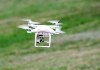 Sahada yeşil çim üzerinde drone iniş.