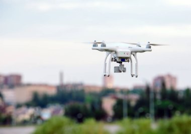 Drone dört helikopter ile şehrin üzerinde uçan uçan yüksek çözünürlüklü dijital fotoğraf makinesi.