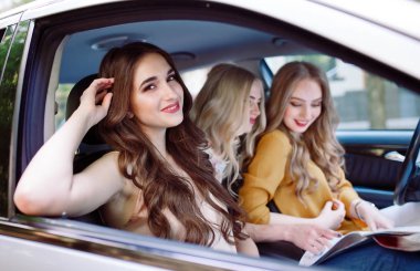 Üç genç kız bir arabada seyahat.