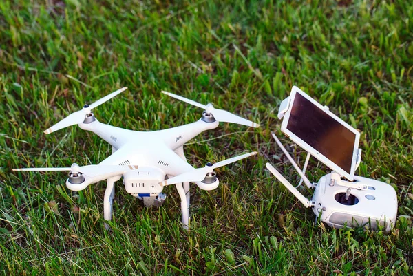 Yüksek çözünürlüklü dijital kamera ile dört helikopter ve onun uzaktan kumanda paneli ile smartphone çimenlerin üzerinde robot. — Stok fotoğraf
