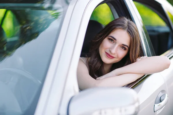 Una joven hermosa chica está conduciendo un coche . — Foto de Stock