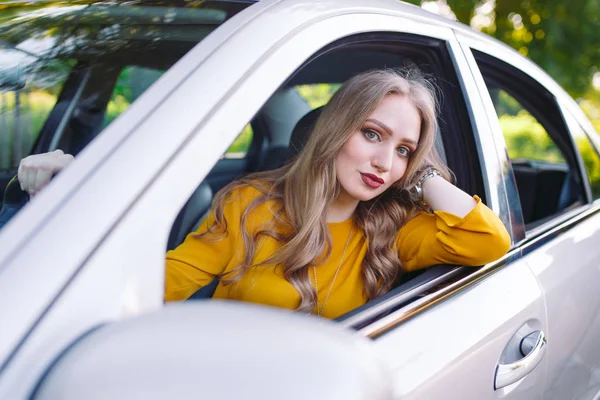 Una joven hermosa chica está conduciendo un coche . — Foto de Stock