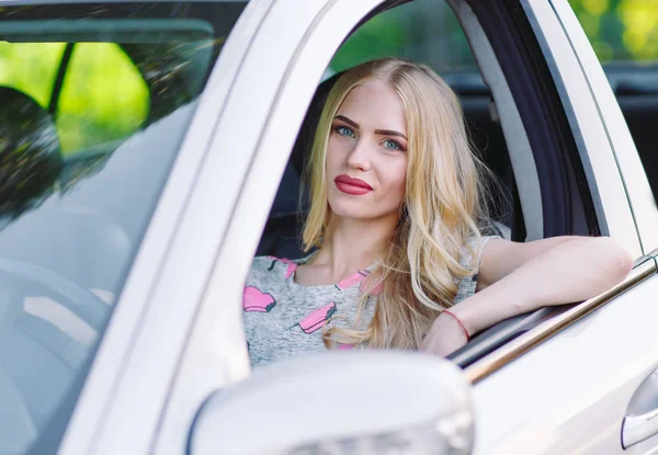 Una joven hermosa chica está conduciendo un coche . — Foto de Stock