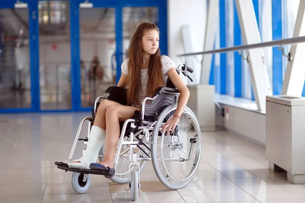 Молодая девушка в инвалидной коляске стоит в коридоре больницы . — стоковое фото