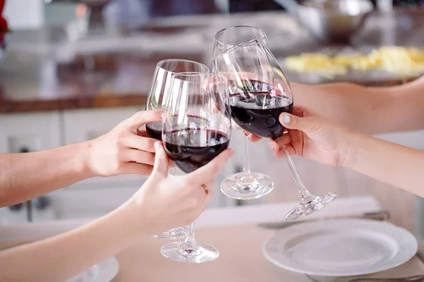 Jovens em um restaurante bebendo vinho no fundo um cozinheiro prepara — Fotografia de Stock