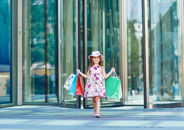 Niedliches kleines Mädchen beim Einkaufen. Porträt eines Kindes mit Einkaufstaschen. Einkaufen. Mädchen. — Stockfoto