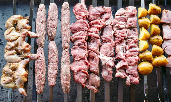 Barbecue from different types of meat in the restaurant on the background of the guests — Stock Photo, Image