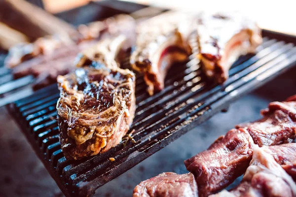 Grandes trozos de carne en escabeche en una rejilla en un restaurante. Carnes a la parrilla mixtas —  Fotos de Stock