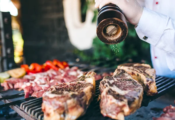 Le Chef prépare la viande sur le barbecue. — Photo