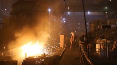 Çelik üretimi için bitki. Elektrikli bir eritme fırını. Fabrika işçisi metal için örnek alıyor.