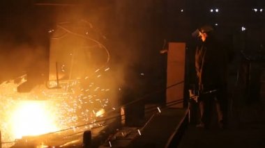Çelik üretimi için bitki. Elektrikli bir eritme fırını. Fabrika işçisi metal için örnek alıyor.